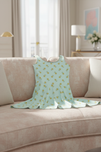 Light blue dress with yellow floral pattern on a beige sofa in a living room.