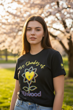 Woman wearing a black t-shirt with a colorful design outdoors