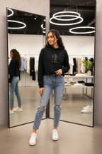 Woman in a black hoodie and ripped jeans standing in front of a mirror in a store.