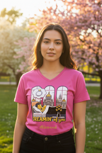 Person wearing a pink t-shirt with a graphic design in an outdoor setting with cherry blossoms.